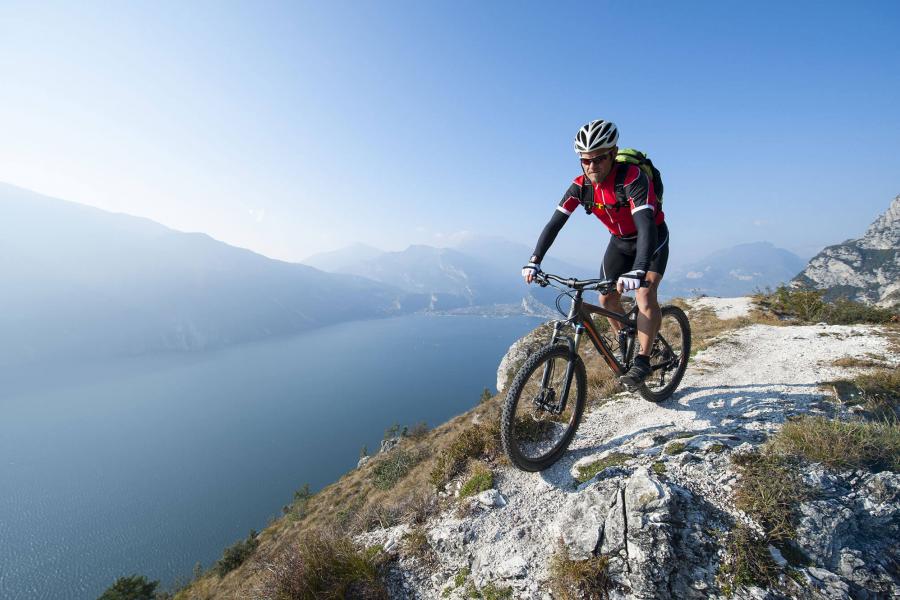 Man mountain biking above a lake