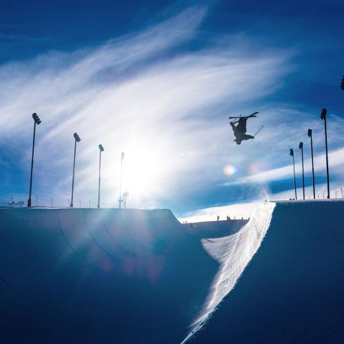 Freestyle skier inverted on half pipe